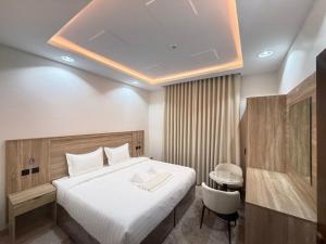 a bedroom with a bed and a table and a chair at فندق ضيافة المدينة in Medina