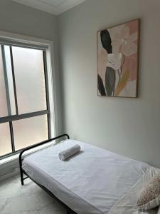 ein Schlafzimmer mit einem Bett und einem Gemälde an der Wand in der Unterkunft Bright Detached Single Room - Near Top Ryde City Shared Amenities in Sydney