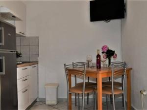 a kitchen with a table with chairs and a bottle of wine at Studio Apartment in Supetar