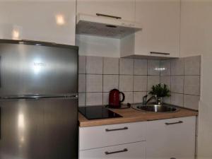 a kitchen with a stainless steel refrigerator and a sink at Studio Apartment in Supetar