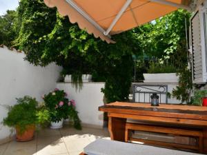 a patio with a wooden table and some plants at Studio Apartment in Supetar +4 photos