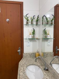 une salle de bain avec deux lavabos et un miroir dans l'établissement Lar Urbano, à Manhuaçu