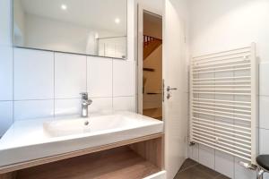 a white bathroom with a sink and a mirror at Ferienhaus in St Peter-Ording in Ording +32 photos