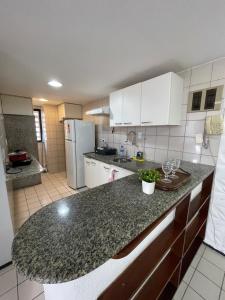 a kitchen with white cabinets and a granite counter top at Flat Mont Blanc - Perto de Tudo! in São Luís