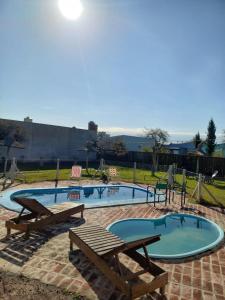una piscina con due panche e un tavolo da picnic di Cabañas Diamante a Gualeguaychú