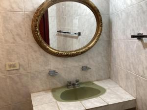a bathroom with a green sink and a mirror at Habitación privada zona Satélite in Mexico City