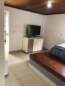 a bedroom with a bed and a flat screen tv at Recanto Urbano Centro histórico in São José