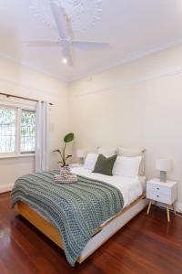 パースにあるFloreat Family Home - With Kids Play Equipmentの白いベッドルーム(ベッド1台、天井ファン付)