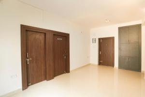 two wooden doors in an empty room with white walls at Super Hotel O Prashant Villa in Rānchī