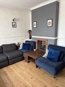 a living room with two couches and a coffee table at 3-bedroom home with large garden and free parking in Loughton