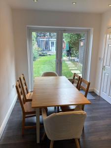 a dining room with a wooden table and chairs at 3-bedroom home with large garden and free parking in Loughton +3 photos