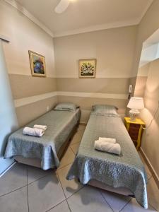 a room with two beds with towels on them at Loft próximo Estádios e Faculdades in Campinas