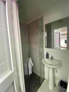 カリにあるApartahotel brisas de los alamosの洗面台と鏡のある白いバスルーム