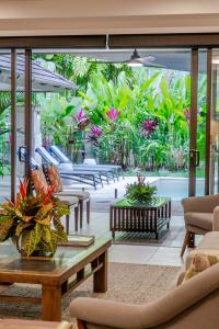 a living room with a view of a garden at SeaEden Port Douglas Apartments in Craiglie