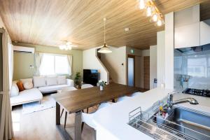 a kitchen and living room with a wooden ceiling at AMP FLAT Baika in Dazaifu