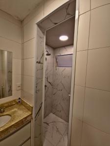 a bathroom with a shower with a sink and a mirror at Apartamento próximo Cambui in Campinas