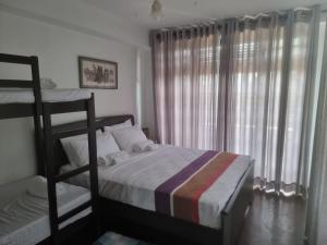 a bedroom with two bunk beds and a window at Villa Omaru Mountain Views Kandy Hanthana in Kandy