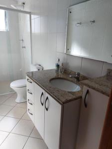 a bathroom with a sink and a toilet at Suíte perto da Vila Germânica, em Blumenau in Blumenau +10 photos