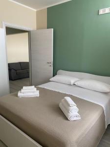 a bedroom with a large bed with towels on it at B&B Costa d'Amalfi Bellizzi in Bellizzi