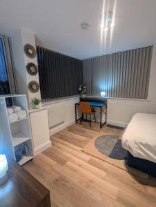 a bedroom with a bed and a desk and a table at Homely & Lush 1 Bed Apartment at Trinity Point Gravesend, Suitable for Long Stay and Short Stay in Gravesend