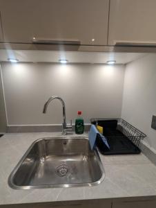 a kitchen sink with a dish rack next to it at Homely & Lush 1 Bed Apartment at Trinity Point Gravesend, Suitable for Long Stay and Short Stay in Gravesend +51 photos