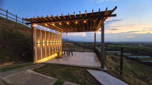 een houten pergola met een tafel op een patio bij LA TRAGONA - Casa Campestre in El Cerrito