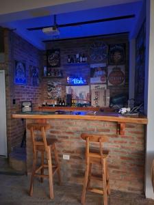 een bar met twee krukken voor een stenen muur bij LA TRAGONA - Casa Campestre in El Cerrito