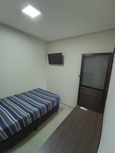 a bedroom with a bed and a flat screen tv at Alojamiento in Santa Rita