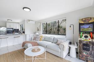 - un salon avec un canapé blanc et un jeu vidéo dans l'établissement Nobby's Arcade - Views Games and Vibes, à Gold Coast