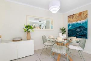 une salle à manger avec une table et des chaises et un tableau dans l'établissement Nobby's Arcade - Views Games and Vibes, à Gold Coast