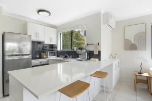 une cuisine blanche avec un grand comptoir blanc dans l'établissement Nobby's Arcade - Views Games and Vibes, à Gold Coast