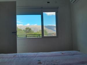 a bedroom with a window with a view of mountains at Lo de guada in Los Molles