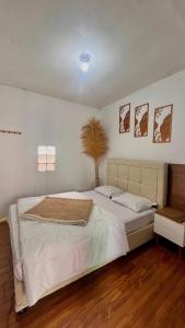a bedroom with a large white bed in a room at Villa kumudini's in Dieng