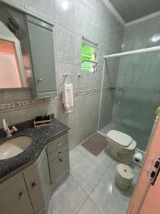 ein Badezimmer mit Dusche, Toilette und Waschbecken in der Unterkunft Residência Vó Nilton in Governador Celso Ramos