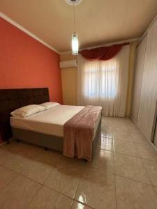 a bedroom with a bed and a red wall at Residência Vó Nilton in Governador Celso Ramos