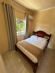 ein Schlafzimmer mit einem großen Bett mit Fenster in der Unterkunft Residência Vó Nilton in Governador Celso Ramos