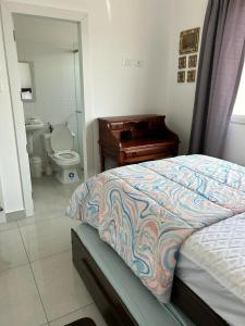 Un dormitorio con una cama y un baño con inodoro. en Pacific Coastal Cabin Shelter, en San Jacinto