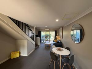 a living room with a staircase and a table and chairs at Weerona in Eaton
