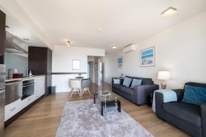 a living room with a couch and a table at Paihia Beachfront 1 Bedroom Aptm in Paihia
