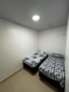 two beds in a small room with at Suspenso aluguel in Belém
