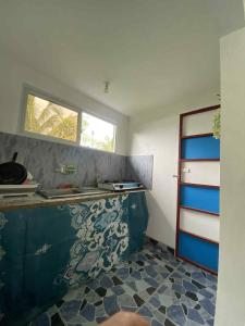 una cucina con un bancone blu e bianco e una finestra di Home Away from Home Besides Salatan's Residence a Moalboal