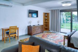 a living room with a couch and a table and a desk at Casa Mariposa in Esterillos