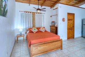 a bedroom with a bed and a ceiling fan at Casa Mariposa in Esterillos +36 photos