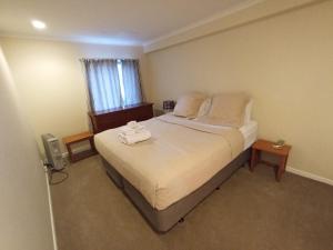 a bedroom with a bed with two towels on it at Auckland City Holiday Escape in Auckland