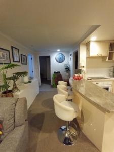 a kitchen and living room with a counter and chairs at Auckland City Holiday Escape in Auckland