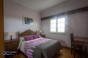 a bedroom with a bed and a desk and a window at Duas Aguas Arribes in Bemposta