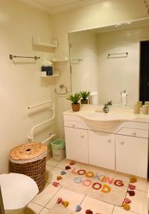 a bathroom with a sink and a toilet and a mirror at Auckland City Holiday Escape in Auckland