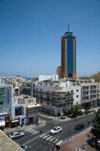 a view of a city street with a tall building at Marco Polo Party Hostel in St. Julianʼs