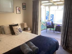 a bedroom with a bed and a sliding glass door at Albert Mews B and B in Whitianga