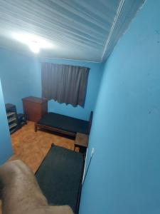 una camera con pareti blu, un letto e una finestra di Hospedagem econômica a Sao Jose do Rio Preto Altre 3 foto